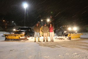 snow plows and trucks and loaders in a snow storm